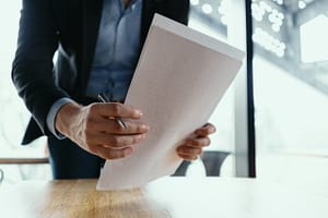 A businessman in a suit holding a stack of papers